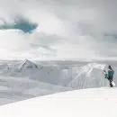 person standing on white snow cliff