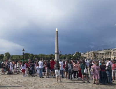 a crowd of people standing in front of a tall tower