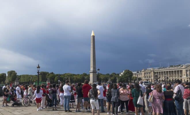 a crowd of people standing in front of a tall tower