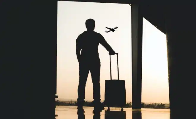 silhouette of man holding luggage inside airport