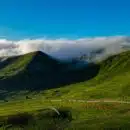 une colline verdoyante couverte de nuages et d’herbe