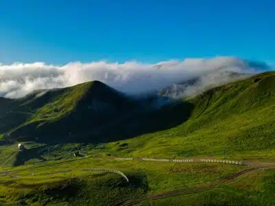 une colline verdoyante couverte de nuages et d’herbe