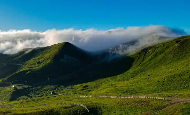 une colline verdoyante couverte de nuages et d’herbe